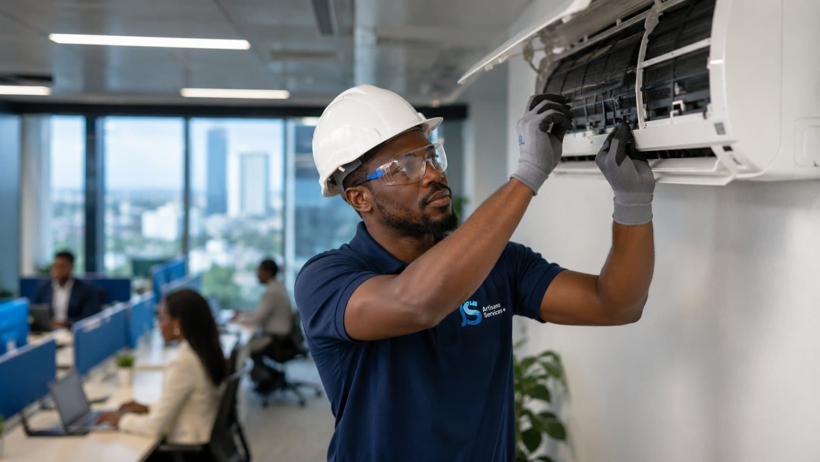 Technicien ASP entretenant un climatiseur mural dans un open space, employés au travail en arrière-plan